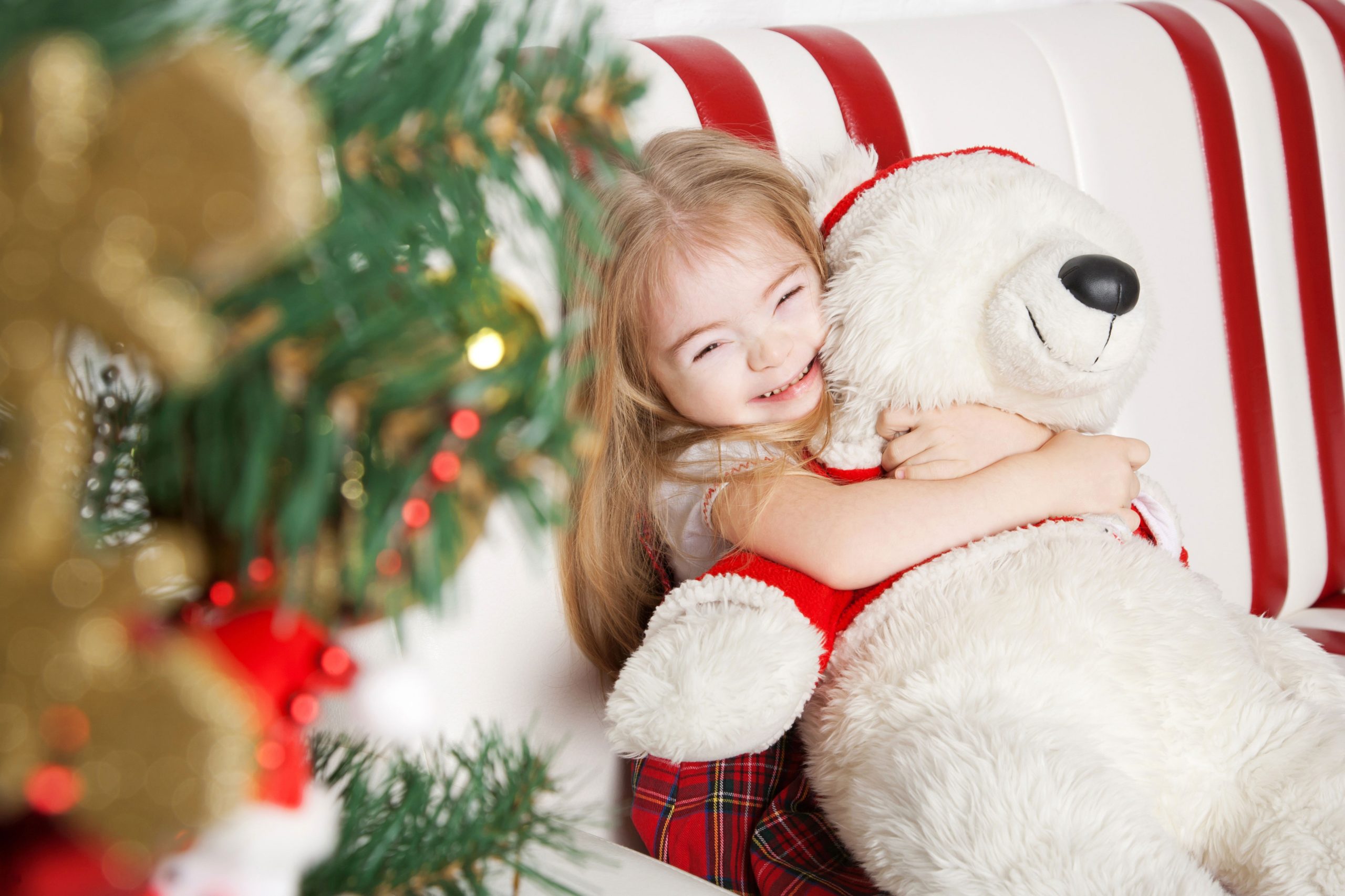 Little girl with down syndrome hugging her christmas present, Christmas Giveaway